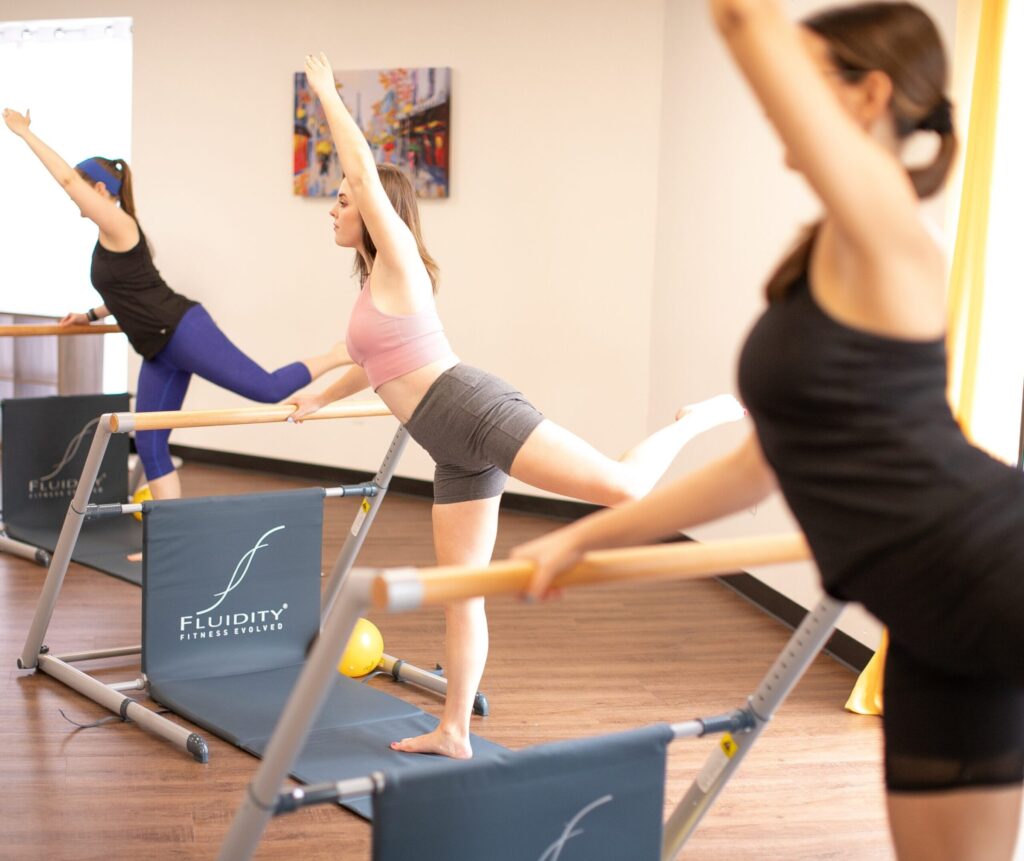 A Barre86 class doing an exercise at the barre in standing