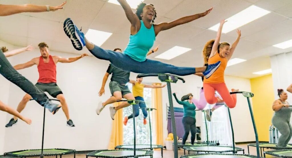 A client doing a big split jump on the mini trampoline