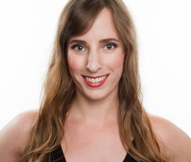Headshot of Heather Daye. She is smiling with her hair down and gently curled. Wearing a black v-neck tank top.